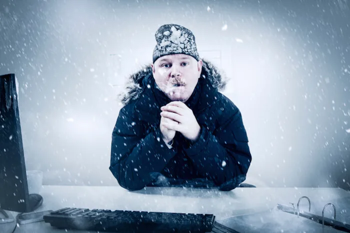 man freezing inside his office