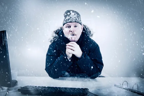 man freezing inside his office