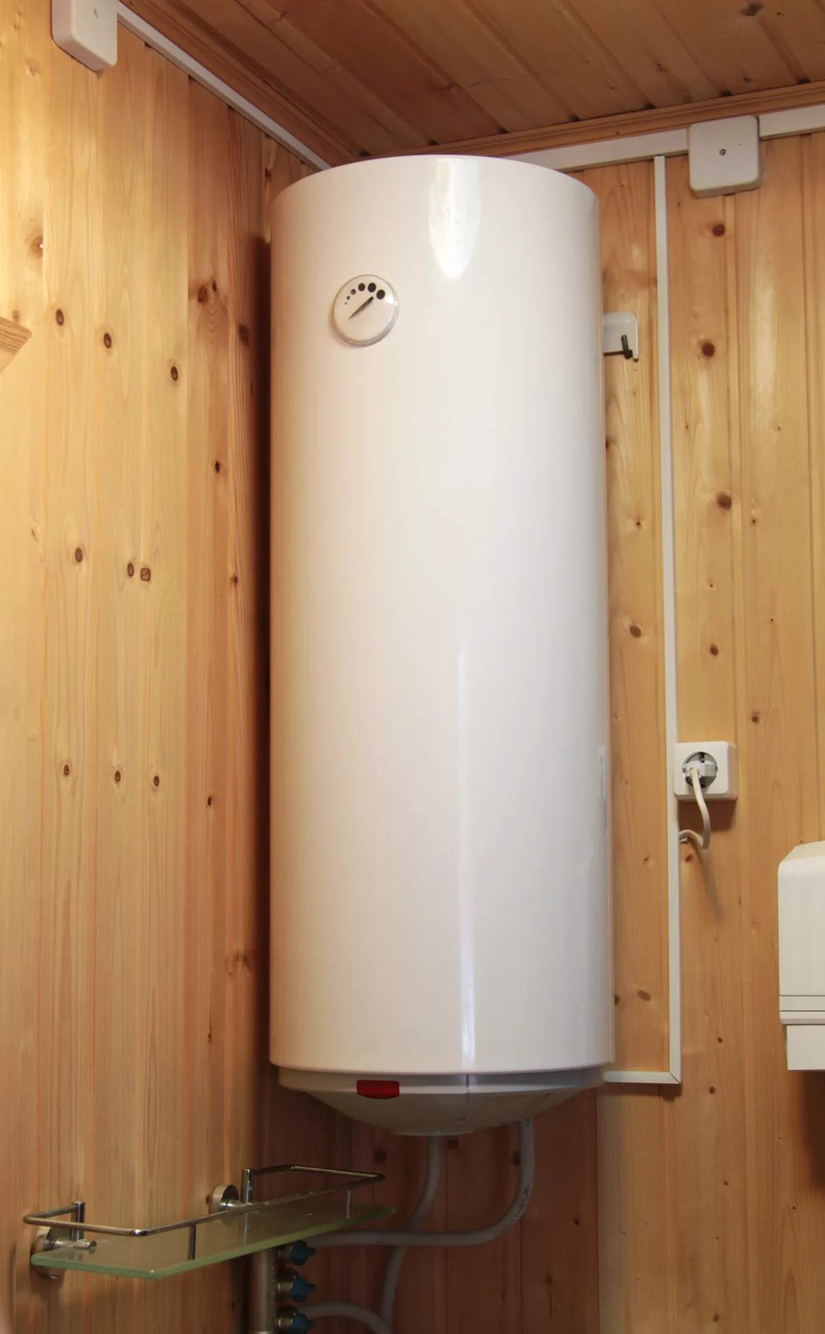 Electric water heater hanging on the wooden wall