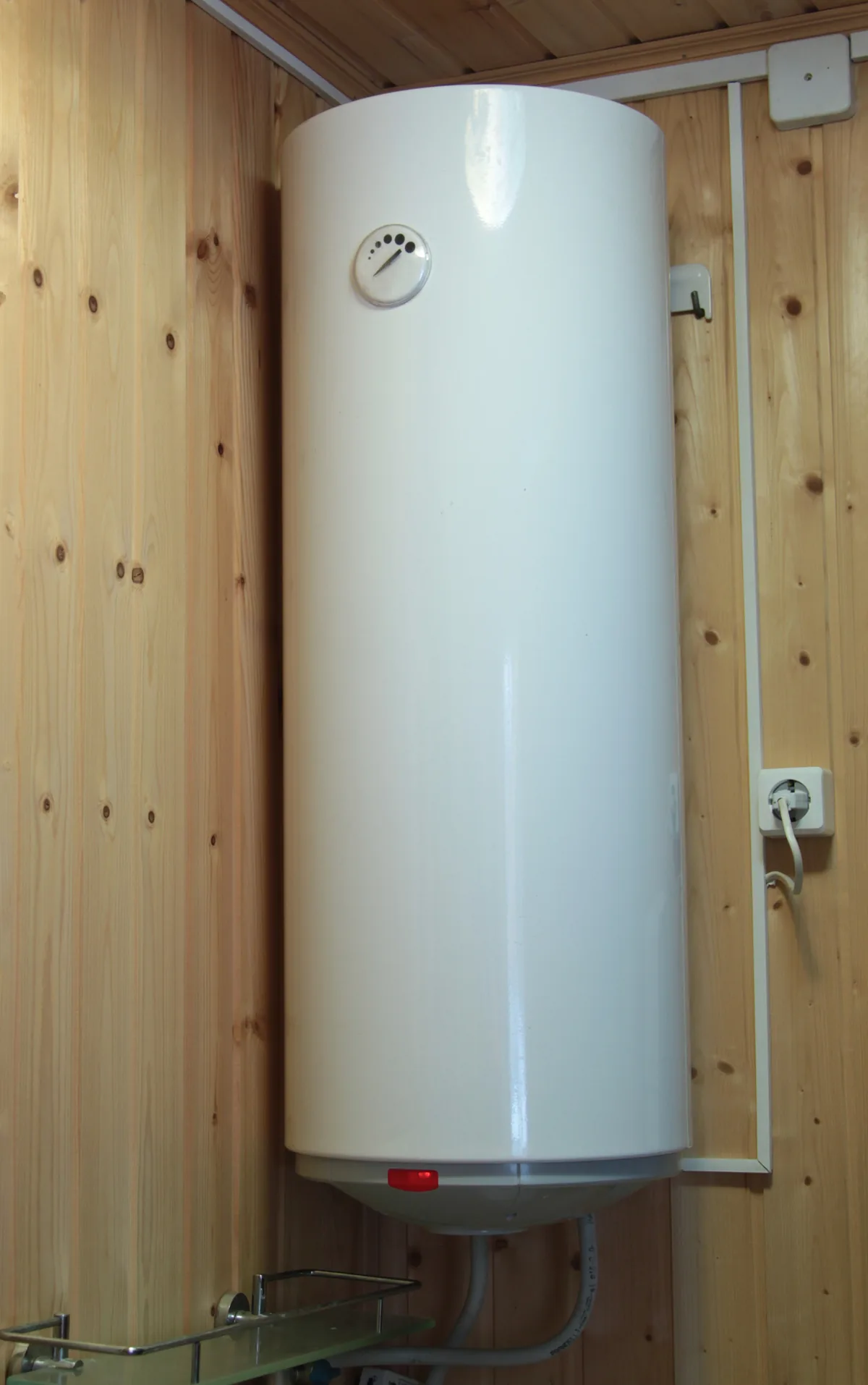 Electric water heater hanging on the wooden wall