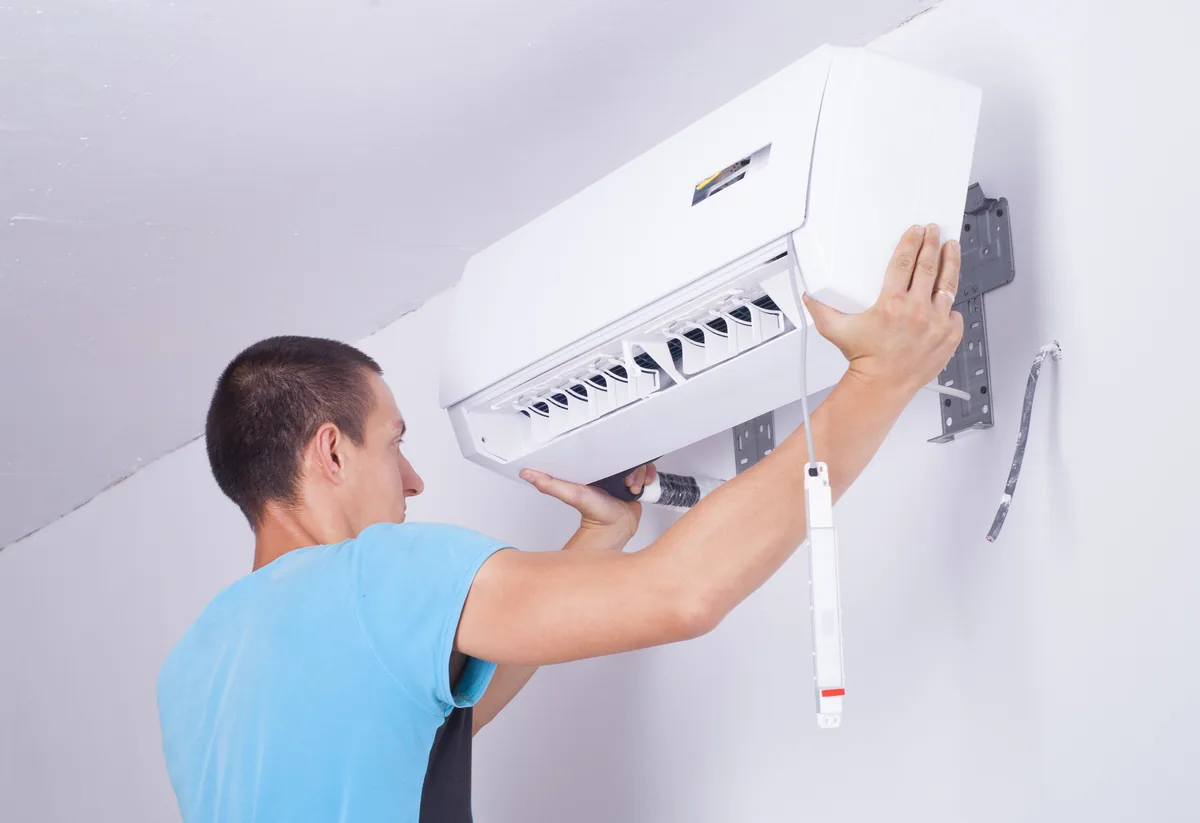 Person servicing a wall-mounted air conditioner
